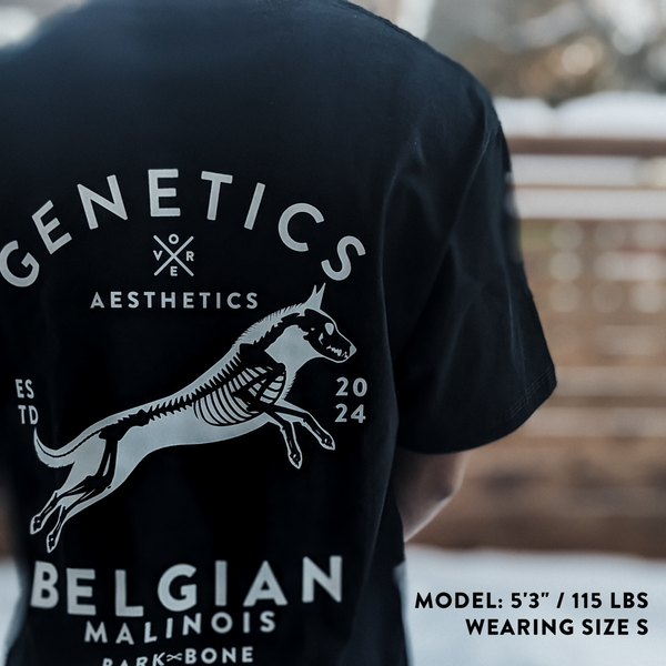 Black Dog Bone t-shirt with 'GENETICS over AESTHETICS' and 'Belgian Malinois' design on the back, worn by a person.